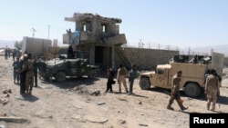 Afghan security forces inspect the aftermath of a suicide bomb blast in Paktia Province on June 18.