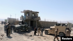 Afghan security forces inspect the aftermath of a suicide bomb blast in Paktia Province on June 18.