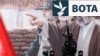 Një oficer i sigurisë iraniane qëndron roje pranë një billbordi me portretin e udhëheqësit të ri suprem të Iranit, Mojtaba Khamenei, në Teheran, më 13 mars.
