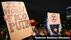 A woman with a poster reading "Bad, worst, Fico, Putin" at a pro-Ukrainian rally in Bratislava on March 12. 