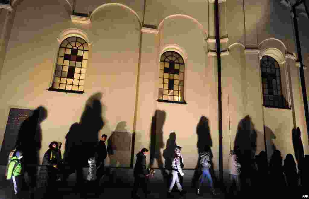 People walk past a church during an Orthodox Christmas Eve ceremony in Sabac, Serbia. (AFP/Andrej Isakovic)