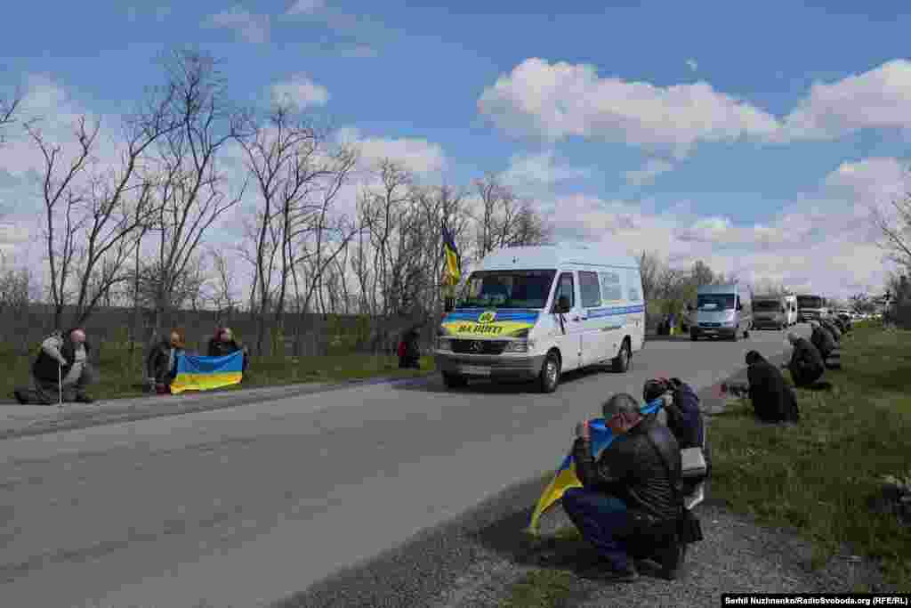 У рідному селі траурну процесію із тілами загиблих на фронті братів Залізняків зустрічають живим коридором з квітами та прапорами у руках. Водяне, Кіровоградщина, 20 квітня 2026 року