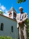 Ivan Gashi para kishës në fshatin Brus.
