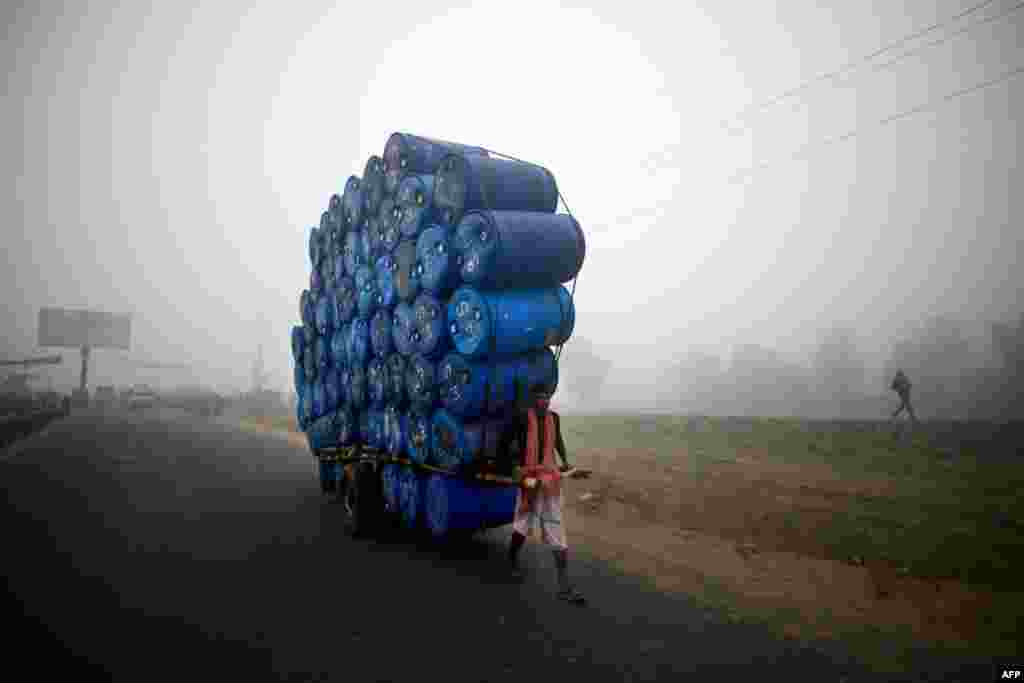 A Bangladeshi laborer pulls a cart full of empty drums during a nationwide strike in Dhaka. Twelve like-minded Islamic parties called an eight-hour general strike in the capital and a dawn-to-dusk general strike across the country as they seek a ban on left-wing political parties. (AFP/Munir uz Zaman)