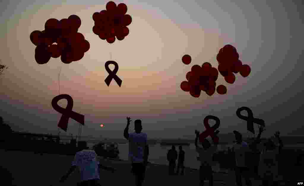 Indian activists and children release ribbons and balloons during an event to mark World AIDS Day in Kolkata. (AFP/Dibyangshu Sarkar)