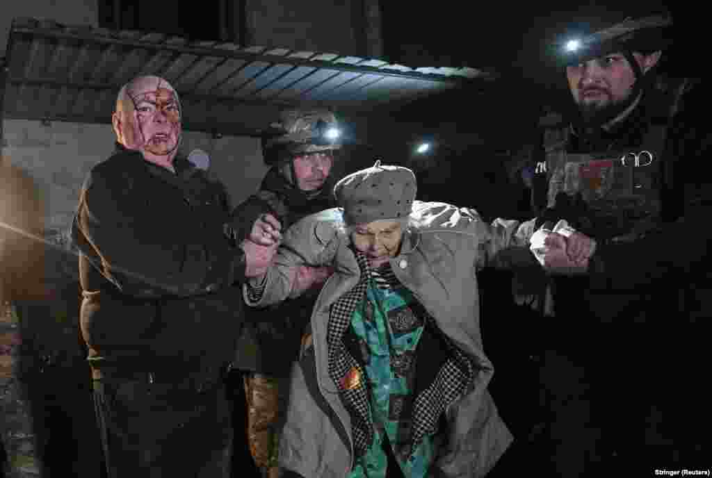  Police officers and a wounded resident evacuate a woman from an apartment building hit by a Russian missile strike in Zaporizhzhya, Ukraine. &nbsp; 