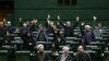 IRAN -- Iranian lawmakers rais their hands to vote during a parliamentary session in Tehran, January 7, 2020