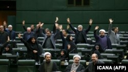 IRAN -- Iranian lawmakers rais their hands to vote during a parliamentary session in Tehran, January 7, 2020