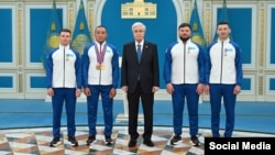 Президент Казахстана Касым Жомарт Токаев, паралимпийский чемпион Ербол Хамитов (второй слева) и тренерский состав спортсмена на церемонии награждения в Астане