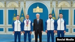 Қазақстан президенті Қасым-Жомарт Тоқаев, паралимпиада чемпионы Ербол Хамитов (сол жақтан екінші) және оның бапкерлері. Астана, 26 наурыз, 2026 жыл.