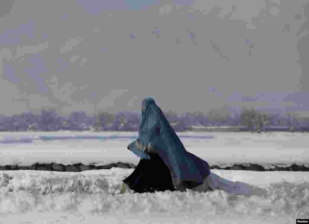 &nbsp;An Afghan woman walks along a street covered with snow on the outskirts of Kabul. (Reuters/Omar Sobhani)