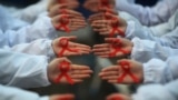 CHINA -- Students hold red ribbons during an event to mark World AIDS Day at a medical college in Yangzhou, Jiangsu province,November 30, 2017