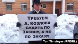 A man in front of a Moscow court protests the prosecution of entrepreneur Aleksei Kozlov.