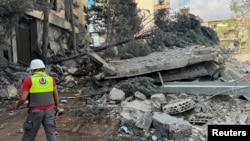 A civil defense member of the Islamic Health Authority walks at a site damaged in an Israeli strike in Nabatieh, southern Lebanon, on October 16.