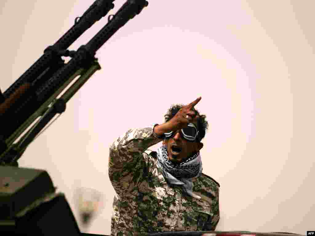 A Libyan rebel gestures as he mans an antiaircraft gun in Ajdabiyah on March 14, as Libyan strongman Muammar Qaddafi's forces shelled rebel positions on the doorstep of the key town, which the revolt against his rule has vowed to defend at all costs. Photo by Patrick Baz for AFP