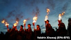 Kosovar Albanians hold torches to mark the 20th anniversary of the death of KLA commander Adem Jashari in the village of Prekaz on March 7.