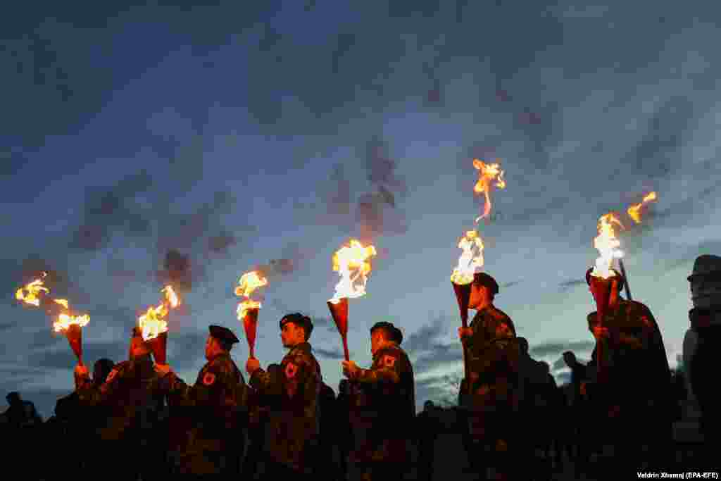 Kosovar Albanians in military costumes hold torches during a bonfire night to mark the 20th anniversary of&nbsp; the death of Kosovo Liberation Army (UCK) Commander Adem Jashari on March 7. (epa-EFE/Valdrin Xhema)