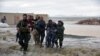 Afghan security forces carry children after flood affected their homes in Arghandab district of Kandahar Province on March 2.