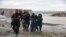Afghan security forces carry children after flood affected their homes in Arghandab district of Kandahar Province on March 2.