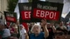 Muškarac drži transparent na kojem na bugarskom jeziku piše "Ne želimo euro" tokom demonstracija protiv ulaska Bugarske u eurozonu u Sofiji 4. juna 2025.