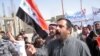 Iraqis shout slogans during a demonstration in Fallujah today against the visit of Iranian President