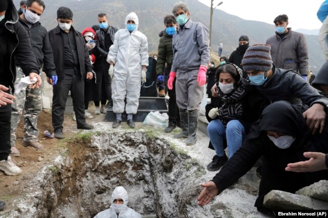 Mourners attend the funeral of a man who died from COVID-19 at a cemetery on the outskirts of the Iranian city of Ghaemshahr on December 16. Officially, the disease has killed more than 56,000 Iranians.