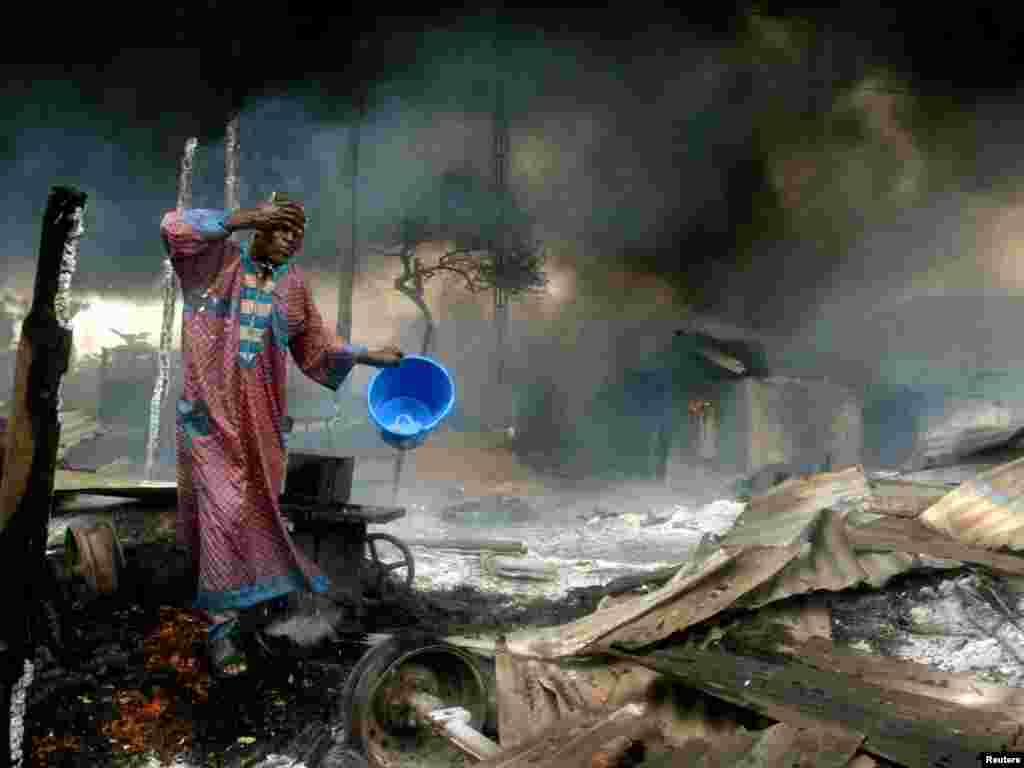 A man rinses soot from his face at the scene of a gas pipeline explosion near Nigeria's commercial capital Lagos December 26, 2006. Up to 500 people were burned alive on Tuesday when fuel from a vandalised pipeline exploded in Nigeria's largest city, Lagos, emergency workers said. Hundreds of residents of the Abule Egba district went to scoop fuel using plastic containers after thieves punctured the underground pipeline overnight to siphon fuel into a road tanker, locals said. REUTERS/Akintunde Akinleye 