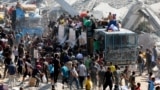 Palesztinok tömegei vették körül a segélyszállító teherautókat Hán Júniszban október 11-én, amikor a humanitárius szállítmányok az újonnan életbe lépett tűzszüneti megállapodás értelmében megérkeztek a városba