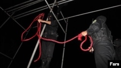 Iranian police officers prepare a rope for a public hanging. 