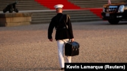 Ось так виглядає американська «ядерна валізка» для запуску міжконтинентальних балістичних ракет. Військовий несе валізку з кодами під час візиту президента США Дональда Трампа до Великої Британії. 12 липня 2018 року