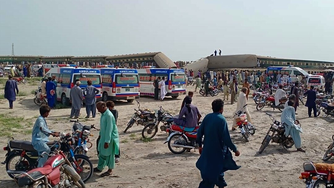 Local residents and ambulances gather beside carriages following the derailment of a passenger train in Nawabshah in the southern Sindh Province on August 6.