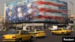 Un panou publicitar în Piața Enqelab din Teheran arată rachete iraniene lovind un portavion american, 26 ianuarie 2026.