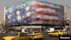 Bilbord na trgu Enkelab u Teheranu prikazuje kako iranske rakete pogađaju američki nosač aviona, 26. januar 2026.