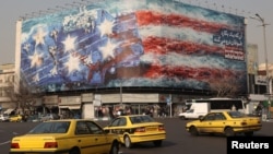 Un panou publicitar în Piața Enqelab din Teheran arată rachete iraniene lovind un portavion american, 26 ianuarie 2026.