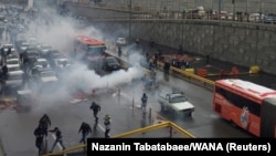 Riot police tries to disperse people as they protest on a highway against increased gas price in Tehran, Iran November 16, 2019.