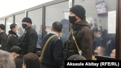 Defendants are seen behind glass in court in Taraz on December 3. 