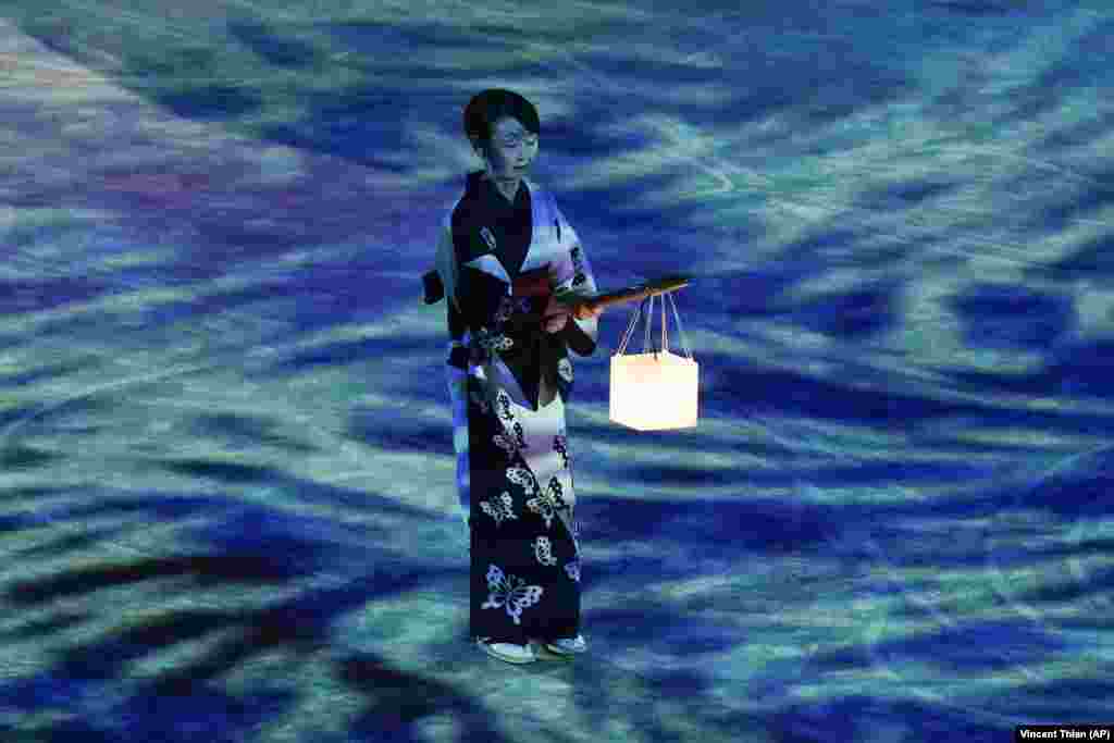 Исполнительница держит фонарь во время церемонии закрытия летних Олимпийских игр в Токио-2020, 8 августа 2021