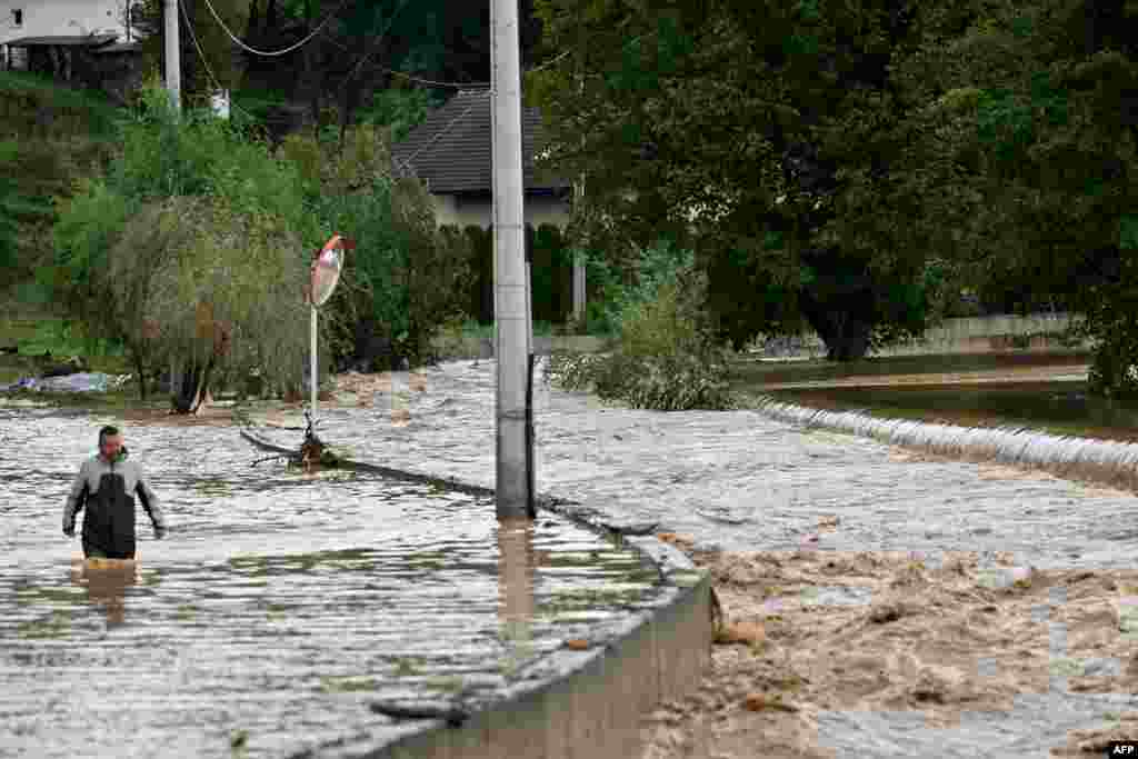 Muškarac hoda u vodi po poplavljenoj cesti nakon jakih kiša u gradu Kiseljaku, dvadesetak kilometara zapadno od Sarajeva 4. 10. 2024.