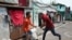 A plainclothes policeman wields his baton against a man as a punishment for breaking the lockdown rules, after India ordered a 21-day nationwide lockdown to limit the spreading of coronavirus disease (COVID-19), in Kolkata on March 25.