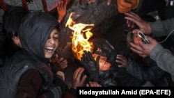 Afghan children gather around a fire to beat the cold in Kabul. (file photo)