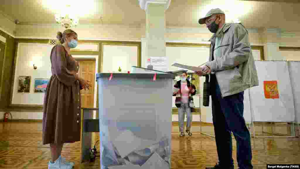 Люди во время голосования на российских выборах на избирательном участке №99, Севастополь
