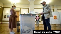 Мужчина голосует на избирательном участке № 99 во время парламентских выборов в России 2021 года, Севастополь 