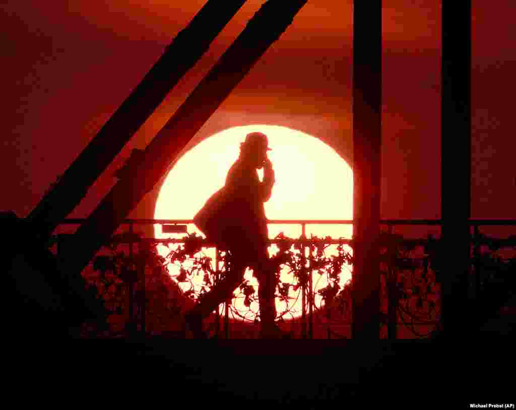 The sun rises behind the Eiserne Steg pedestrian bridge in Frankfurt, Germany, early on April 2. (AP/Michael Probst)