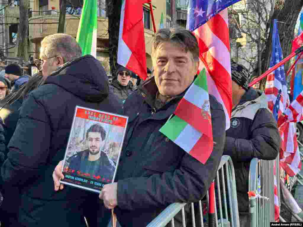 Unul dintre protestatarii din fața Ambsadei Iranului la București ține în mână portretul uneia dintre victimele represiunii din Iran.