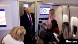 US President Donald Trump talks to members of the media aboard Air Force One on April 17.