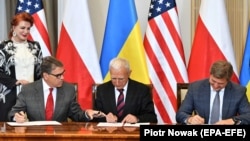 U.S. Energy Secretary Rick Perry (left to right), Polish energy official Piotr Naimski, and Ukrainian National Security and Defense Council chief Oleksandr Danylyuk sign an accord in Warsaw on August 31.