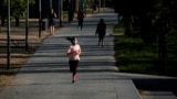 FILE PHOTO: A woman wearing a protective face mask runs in Madrid Rio park, during the hours allowed for individual exercise, for the first time since the lockdown was announced on March 14, amid the coronavirus disease (COVID-19) outbreak, in Madrid, Spa