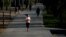 FILE PHOTO: A woman wearing a protective face mask runs in Madrid Rio park, during the hours allowed for individual exercise, for the first time since the lockdown was announced on March 14, amid the coronavirus disease (COVID-19) outbreak, in Madrid, Spa