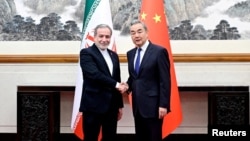 Chinese Foreign Minister Wang Yi (right) meets his Iranian counterpart, Abbas Araqchi, in Beijing on May 9. 