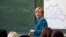 Канцлер Германии Ангела Меркель читает лекцию, написав свое имя на доске, в классе гимназии имени Генриха Шлимана, средней школы в Берлине, 13 августа 2013 года. Меркель прочитала лекцию о строительстве в 12-м классе 